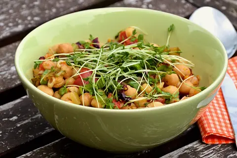 Yeşil kâsede filizlerle süslenmiş nohut salatası
