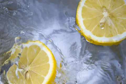 Berrak suyun içinde sıçrayan taze limon dilimleri